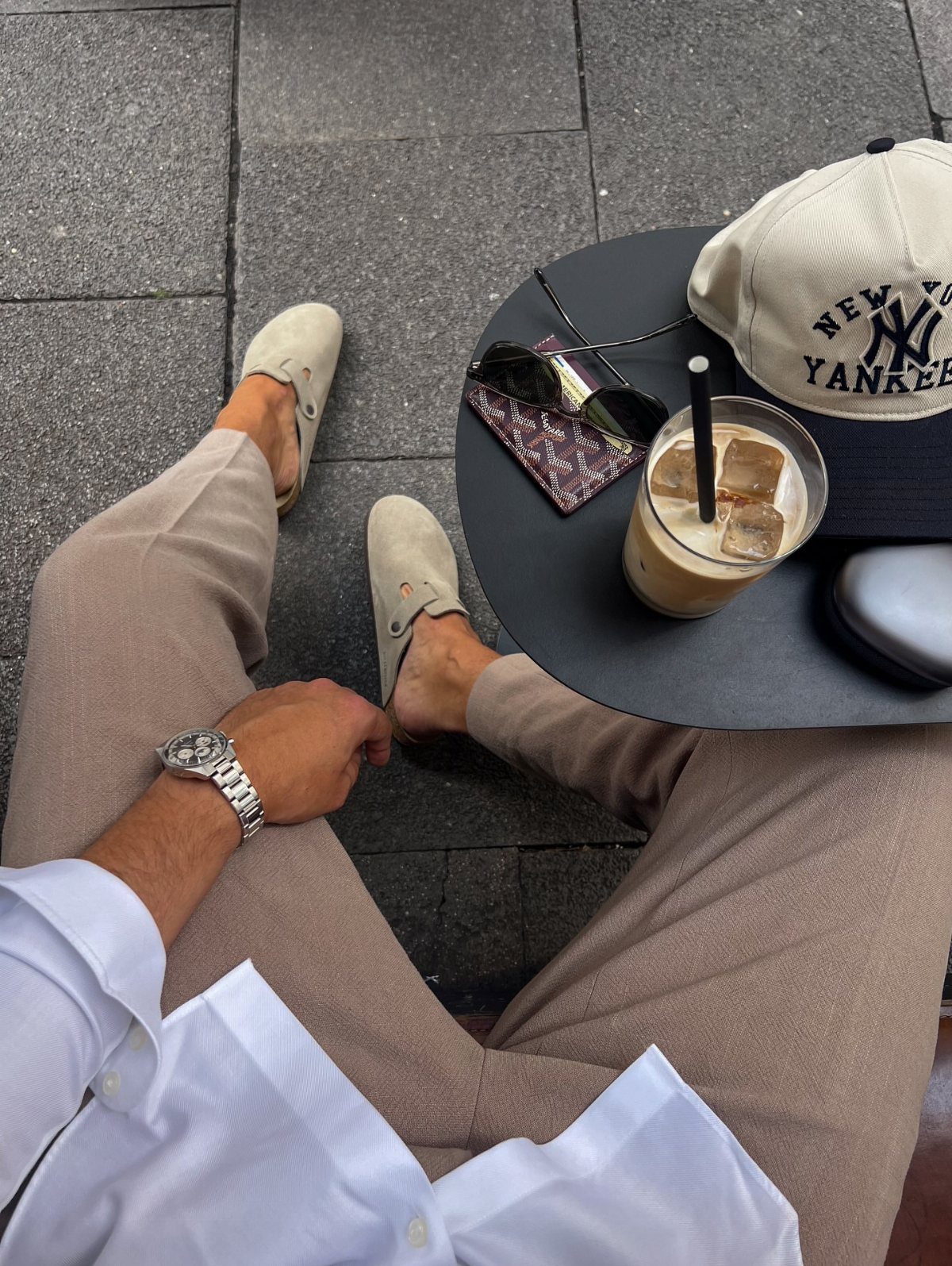 Beige suede loafers and tan trousers paired with a white shirt and silver watch.