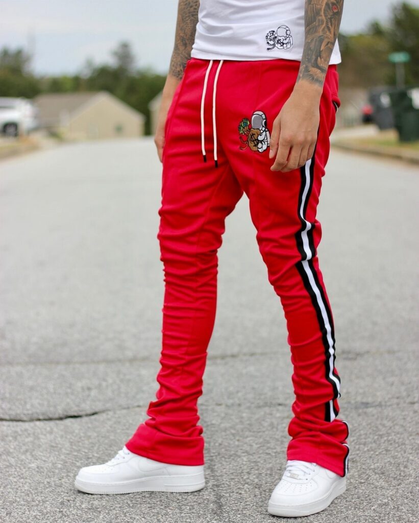 Person wearing red striped track pants, white t-shirt, and white platform sneakers.